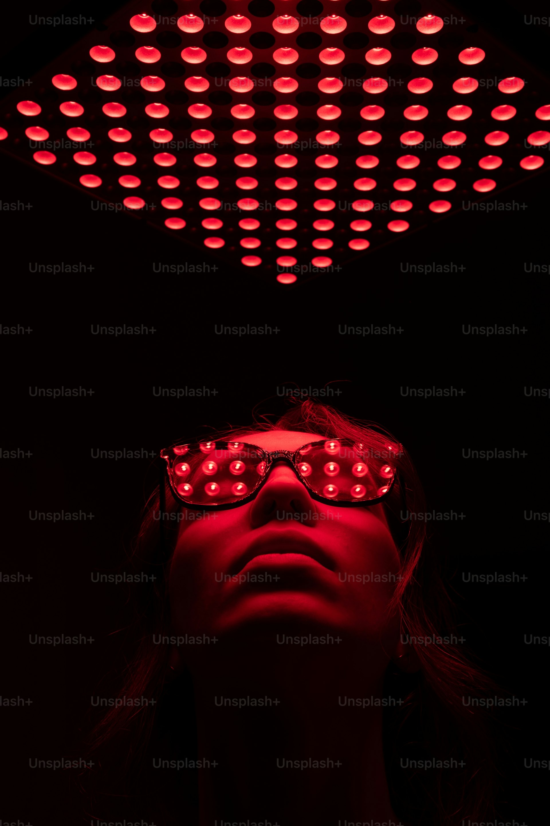 Woman bathed in red light from a therapy panel